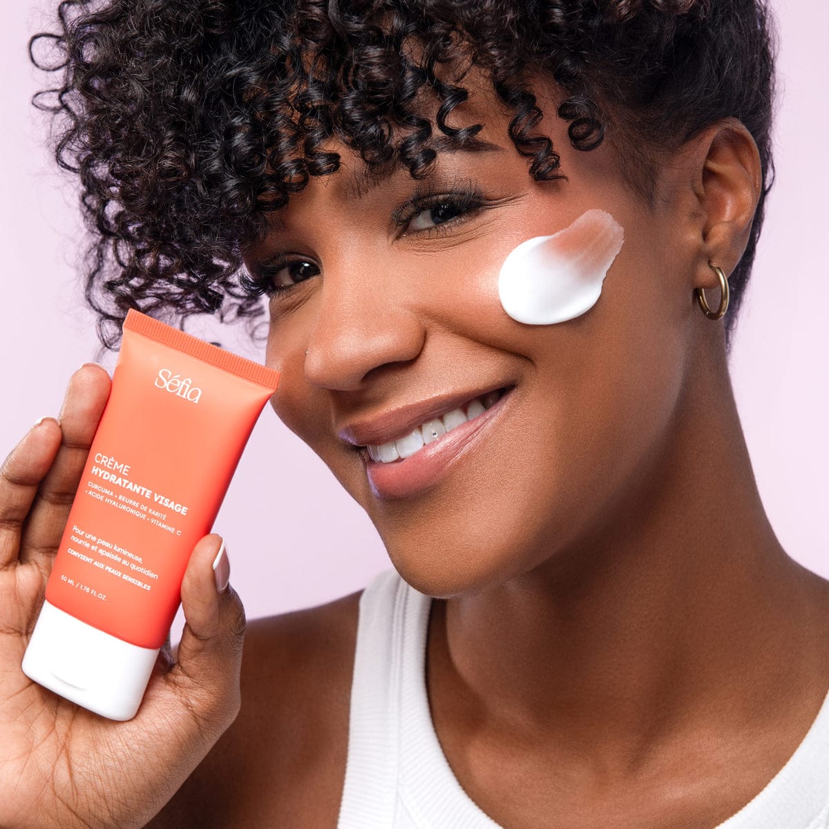 La Crème Hydratante Unifiante appliquée sur la joue